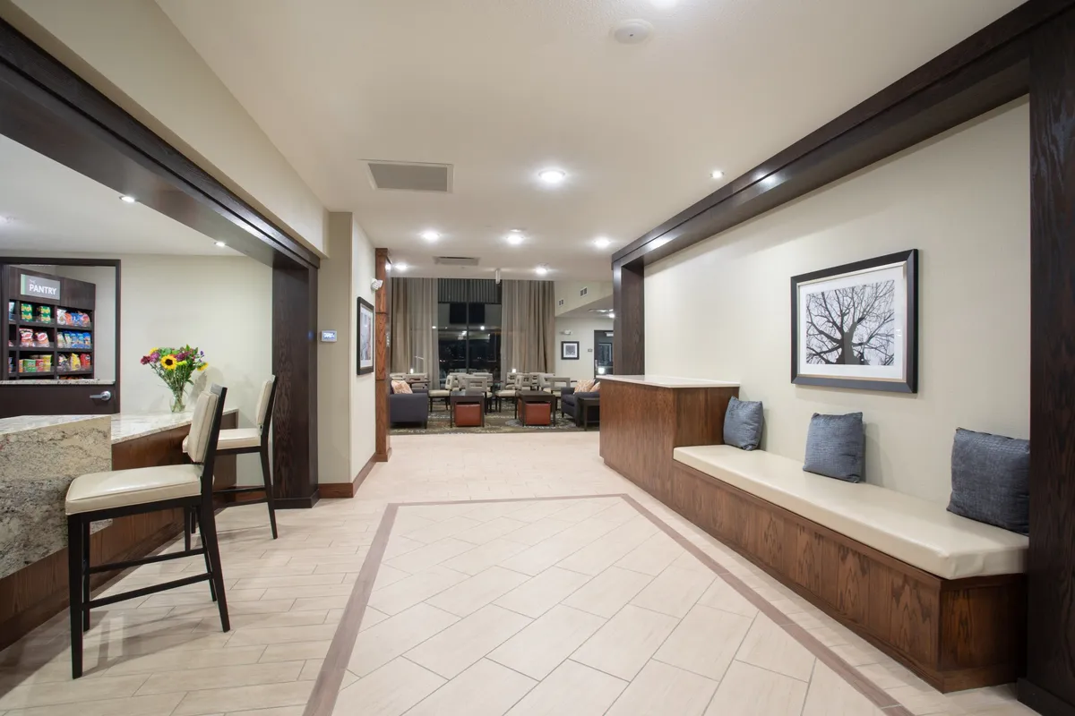 A cozy reception area with a stylish seating nook, eye-catching local artwork, and fresh flowers on the counter. The warm, inviting ambiance encourages casual conversations and welcomes guests after a day out exploring.